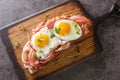 Strammer Max is a German open faced sandwich with ham and eggs closeup on the wooden board. Horizontal top view