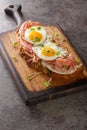 Strammer Max is a traditional sandwich dishes in German cuisine closeup on the wooden board. Vertical