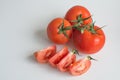 A Strand Of Three Whole Truss Tomatoes And Sliced Tomatoes