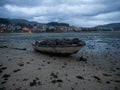 Stranded beached fishing boat vessle ship on coastline shore of seaside town village Combarro Galicia Spain at low tide