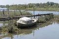 stranded boat at rundown pier on Quaranta canal banks, near Cona island conservation area, Staranzano, Friuli, Italy