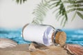 Stranded bottle message note paper with cork on a beautiful holiday beach on the ocean sea with palms and shells Royalty Free Stock Photo