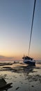 Stranded fishing boat at the beach.  The tide is low. But the sunset was the perfect background in this scene Royalty Free Stock Photo