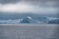 Stranded icebergs in the fog at the mouth of the Icefjord near Ilulissat. Nature and landscapes of Greenland. Travel on