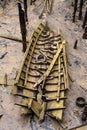 Stranded wreck of the little wooden boat with pieces of wood all around after storm