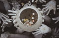 Strange hands hold a pot of coins. Chiang Rai, white temple. Thailand Royalty Free Stock Photo