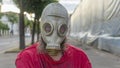 Strange man in a gas mask standing on the street in an empty city. Man wearing anti-pollution, anti-smog and viruses face mask Royalty Free Stock Photo
