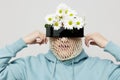 a strange man stands on a light background in a blue hoodie with a mesh and black glasses covering his eyes, turning his Royalty Free Stock Photo