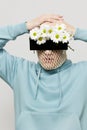 a strange man stands on a light background with a mesh and black glasses covering his eyes, turning his face to the Royalty Free Stock Photo