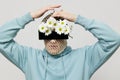 a strange man stands on a light background with a mesh and black glasses covering his eyes, turning his face to the Royalty Free Stock Photo