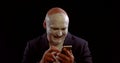Strange man with white makeup on face is laughing and using cell phone, touching sensor screen