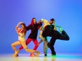 Group of young people, guys and girls in dancing contemporary dance, hip-hop, brakedance over blue background in neon Royalty Free Stock Photo
