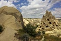 A strange, pointed rock with caves rises against the background of a blue sky Royalty Free Stock Photo