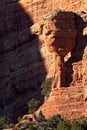 Strange column of rock at Fay Canyon Arch, in the Red Rocks of Sedona, Arizona. Green juniper are growing in the foreground. Royalty Free Stock Photo