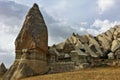 Strange rocks of Cappadocia. Against the background of the cloudy sky, unusual pointed mountains of a fanciful form rise.