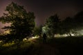 Strange silhouette in a dark spooky forest at night, mystical landscape surreal lights with creepy man Royalty Free Stock Photo