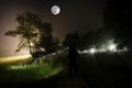 Strange silhouette in a dark spooky forest at night, mystical landscape surreal lights with creepy man Royalty Free Stock Photo