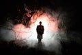 strange silhouette in a dark spooky forest at night, mystical landscape surreal lights with creepy man. Toned Royalty Free Stock Photo