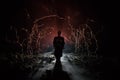 strange silhouette in a dark spooky forest at night, mystical landscape surreal lights with creepy man. Toned Royalty Free Stock Photo