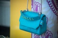 Closeup of blue leather handbag by Lancel Paris in a luxury fashion store showroom