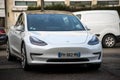 Front view of white testa car parked in the street, tesla is the famous american brand of electric cars