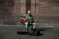 Musician playing guitar in the street by sunny day