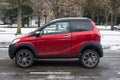 Profile view of red whithout licence car by Aixam company parked in the street