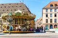 Old vintage carousel merry-go-round in the PLace Kleber, Strasbourg with people admiring the majestic attraction and the surround