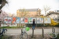 Adult woman walking near all candidate electoral campaign poster near polling