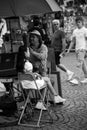 Portrait of asian tourist posing for a painter artist in the street in black and white