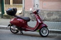 Profile view of red vespa scooter parked in the street