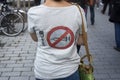 woman protesting in the street against the sanitary pass with symbol on the back of her tee-shirt