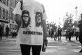 Portrait on back view of woman protesting in the street with the che guevara and bob marley portrait on shirt with text REVOLUTION