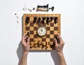 A strategic chess game in progress under time pressure with hands manipulating pieces Royalty Free Stock Photo