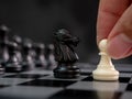 Strategic planning business competition concept. Hand holding white pawn moving playing chess board game. Leader and teamwork to Royalty Free Stock Photo