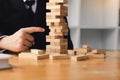 Strategic thinking and risk by business people pulls wooden blocks from the group