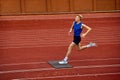 Strategically timed leap for optimal distance. Young attractive sportsman running on sport court to make a perfect long
