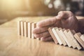 Strategy and successful intervention concept for business, businessman hand Stopping Falling wooden Dominoes effect from Royalty Free Stock Photo