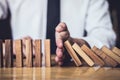 Strategy and successful intervention concept for business, businessman hand Stopping Falling wooden Dominoes effect from Royalty Free Stock Photo