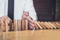 Strategy and successful intervention concept for business, businessman hand Stopping Falling wooden Dominoes effect from Royalty Free Stock Photo