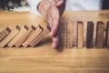 Strategy and successful intervention concept for business, businessman hand Stopping Falling wooden Dominoes effect from Royalty Free Stock Photo