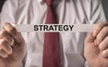 Strategy word in hands of businessman. Concept of strategical planning