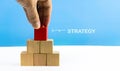 STRATEGY word on red wood cube block stack with blue background Royalty Free Stock Photo