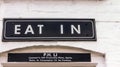 Vintage eat out sign in white painted brick wall