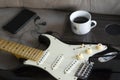 A stratocaster guitar, a classic coffee mug andearphones