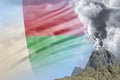 Stratovolcano blast eruption at day time with white smoke on Madagascar flag background, suffer from natural disaster and volcanic