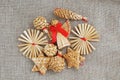 A straw angel with a red bow and Christmas decoration made of straw on brown canvas fabric Royalty Free Stock Photo