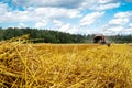 Straw on the background of a blurred combine Royalty Free Stock Photo