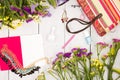 straw bag, colorful flowers, notepad, cosmetics makeup, bijou and essentials on white wooden background Royalty Free Stock Photo