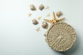 Straw bag and seashells on white background